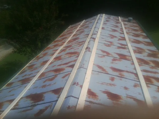 Rusted metal roof panels with new wood purlins before replacement — Storm Damage Roof Repair in Vona by Roofing Brothers