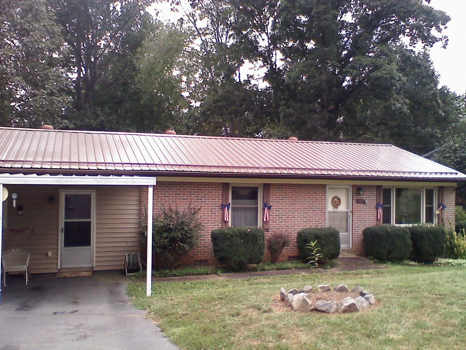 Bronze metal roof and carport on a brick ranch home — Roof Repair work by our crew in Vona