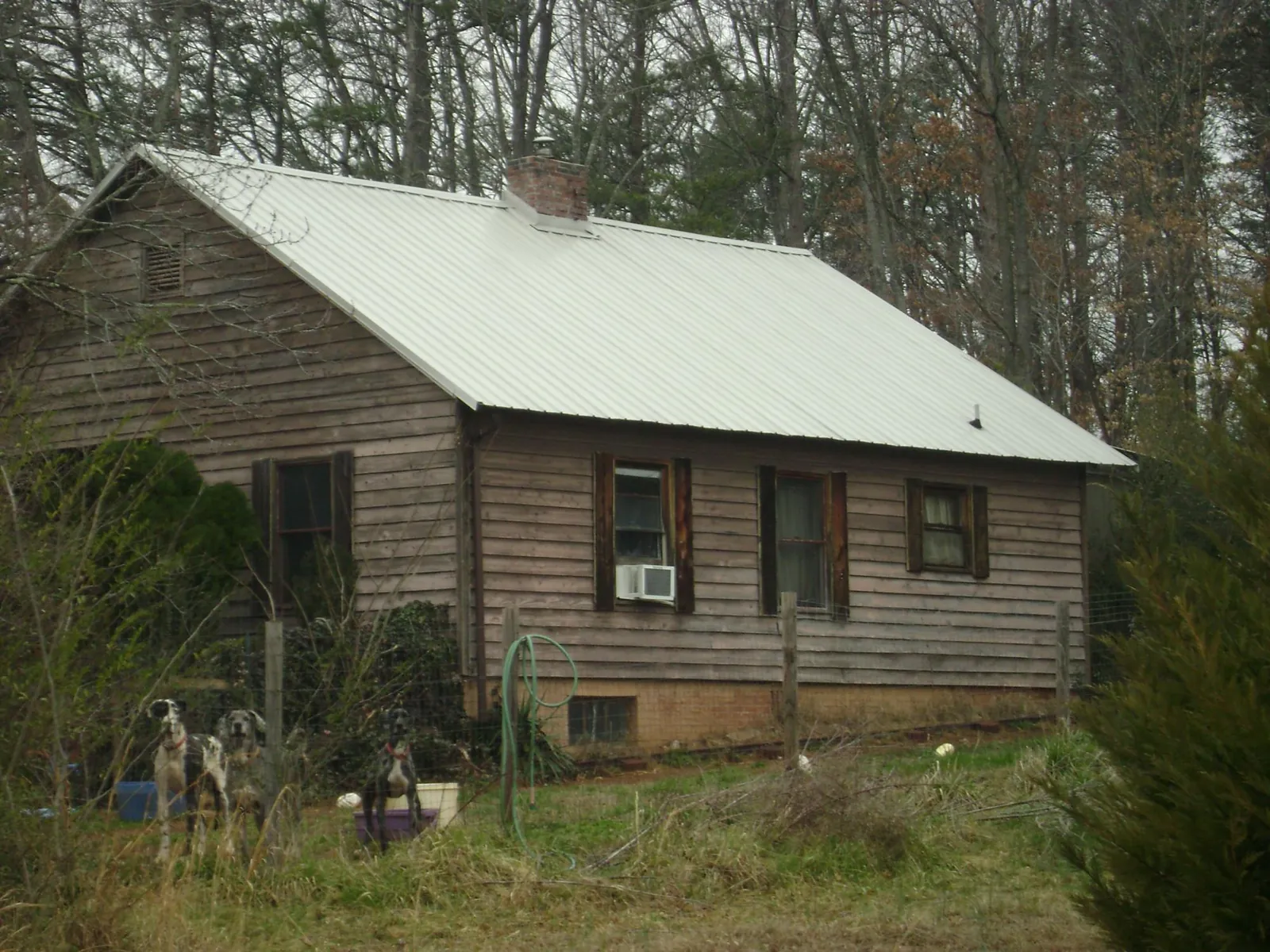White metal roof on an old wood sided farmhouse, from a Metal Roof Installation job in Vona